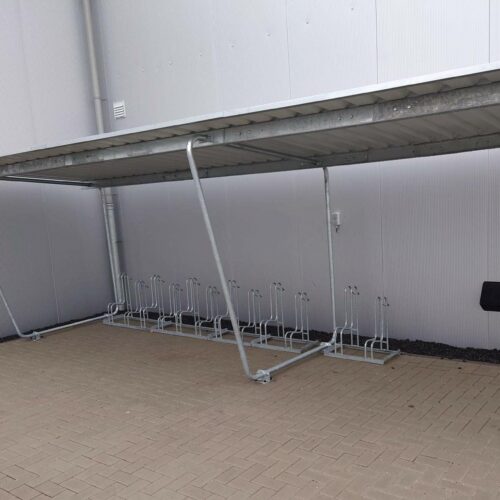 Fietsoverkapping Karin 55 Fietsoverkapping model Karin tegen een muur geplaatst zonder achterwand. Lengte 8.6m. Een nette en verrassend voordelige oplossing. Deze is tevens voor een gedeelte vorozien van onze hoog-laag fietsenrekken model 4000. Door de hoge achterkant een uitstekend fietsenrek.